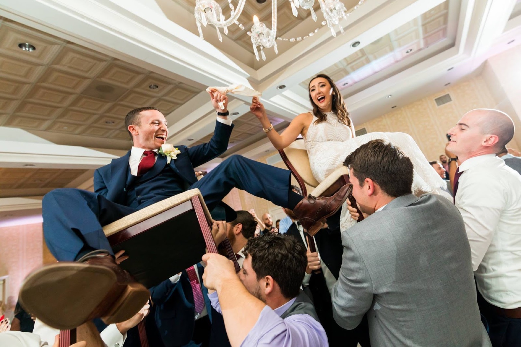 Newlyweds lifted on chairs
