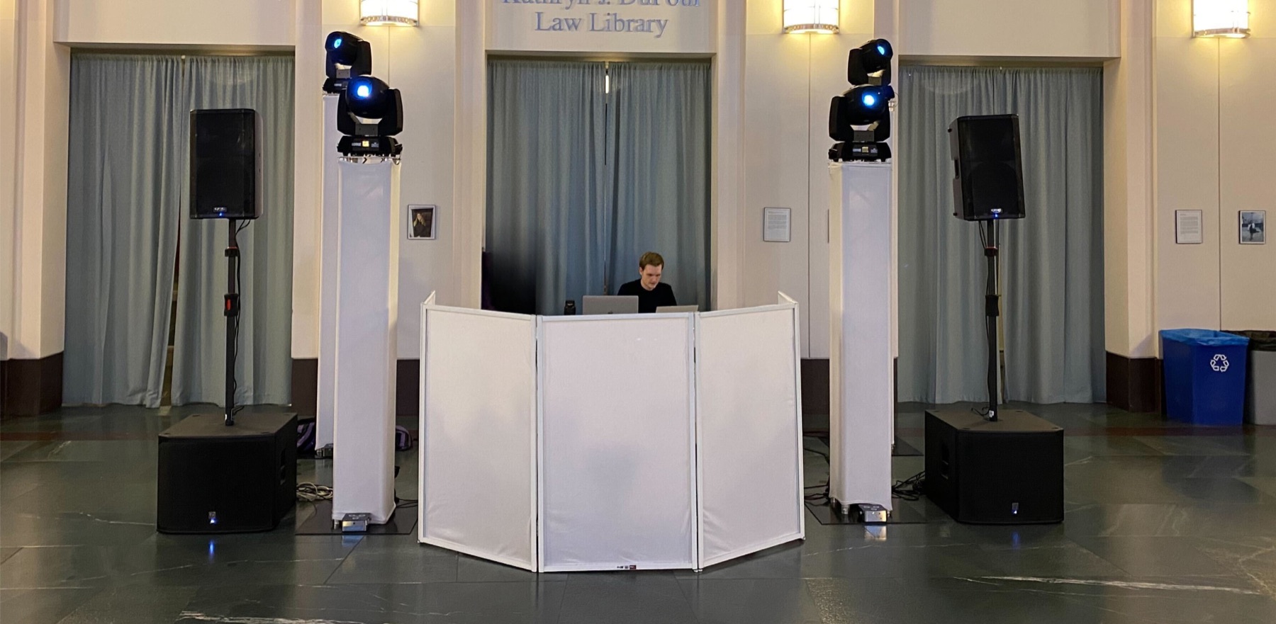 A DJ booth set up between lighting towers